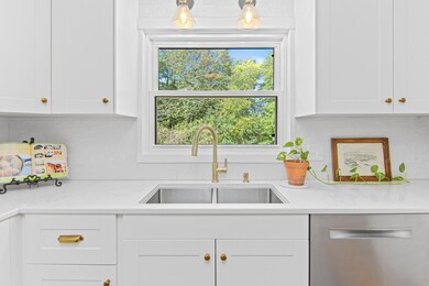 Kitchen window overlooks the wooded backyard