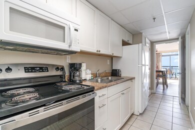 Kitchen with a drop ceiling, white appliances, sin