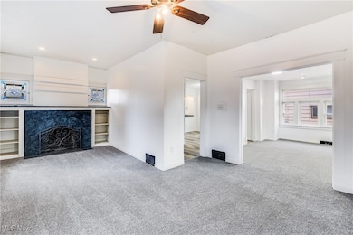 Unfurnished living room featuring light carpet, ceiling fan, and recessed lighting