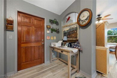 Foyer entrance featuring ceiling fan, light hardwo