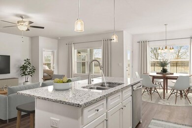 Kitchen featuring a sink, open floor plan, dishwasher, and light wood-type flooring