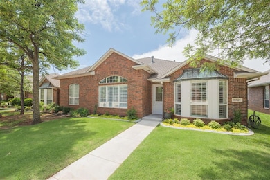 View of front of home featuring brick siding, a front lawn, and roof with shingles