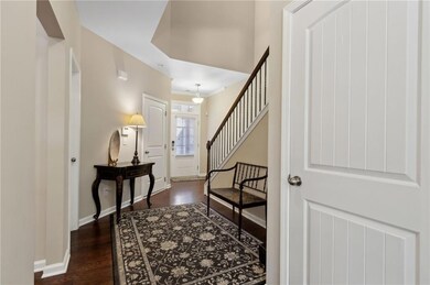 Foyer entrance with dark wood-style flooring, baseboards, and stairway