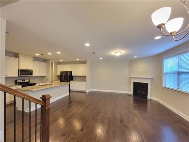 Living area featuring dark wood-style floors, a fi