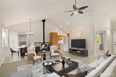 Virtually staged front room and dining area. Vaulted ceilings throughout main living area. Living room and slider curtains do not stay with the home. The open door on the right is a bedroom.