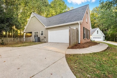 View of home's exterior featuring a shingled roof, brick siding, and concrete driveway