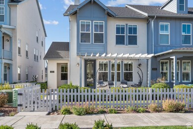 View of front of property with a shingled roof, a fenced front yard, and a patio
