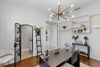 Office area featuring crown molding, wood finished floors, and a chandelier