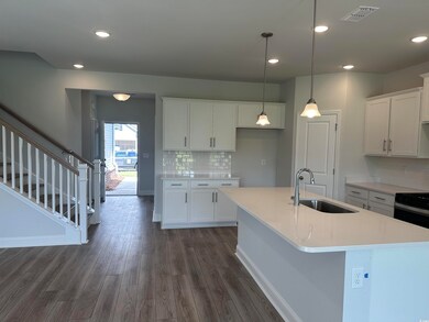 Kitchen with tasteful backsplash, white cabinets, 