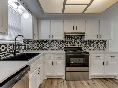 Kitchen featuring under cabinet range hood, a sink