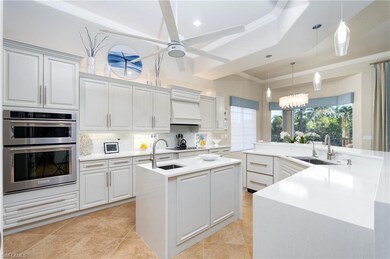 Kitchen featuring pendant lighting, backsplash, double oven, light stone counters, and ornamental molding