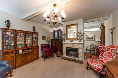 Living area has beamed ceiling, pretty chandelier,