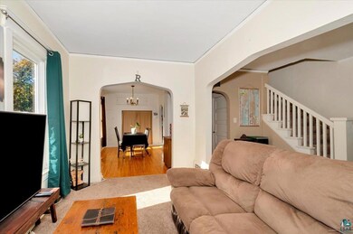 Living room with a notable chandelier, hardwood / 