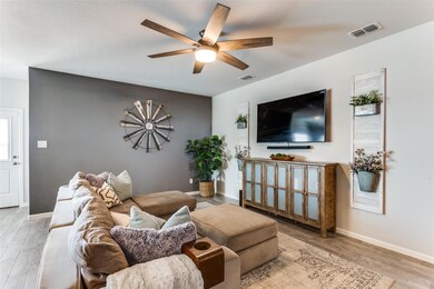 Living room with baseboards, visible vents, wood f