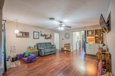 Living room featuring a textured ceiling, hardwood / wood-style floors, and ceiling fan