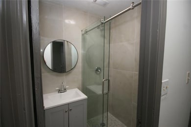 Bathroom with a shower with door and vanity