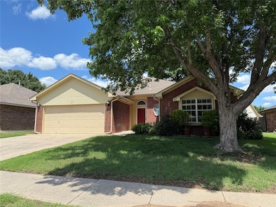 Nice house featuring an attached garage, driveway, brick siding, and a front lawn