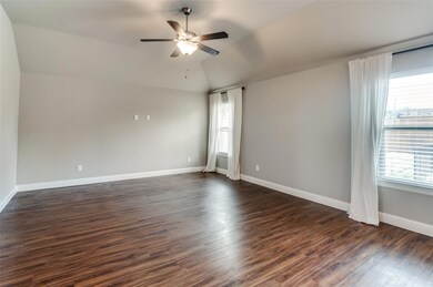 Spare room with lofted ceiling, ceiling fan, a wealth of natural light, and dark hardwood / wood-style floors