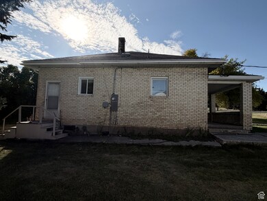 Rear view of property featuring a yard, brick siding, a patio, and a chimney