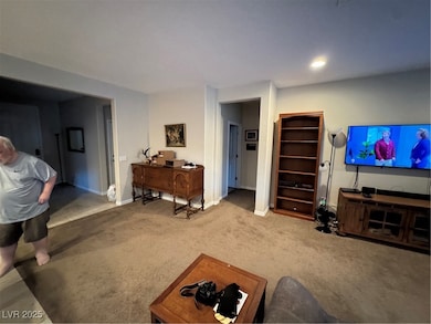 Carpeted living area featuring baseboards and rece