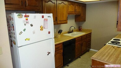 Kitchen has tile floors, lots of cabinets and a gr