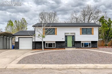 Raised ranch with a carport, fence, a garage, and 