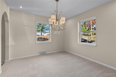 Unfurnished room featuring light carpet, arched walkways, a chandelier, and recessed lighting