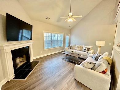 Living room featuring baseboards, a tiled fireplac