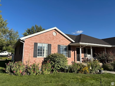 View of front of property with a front yard, covered porch, and brick siding