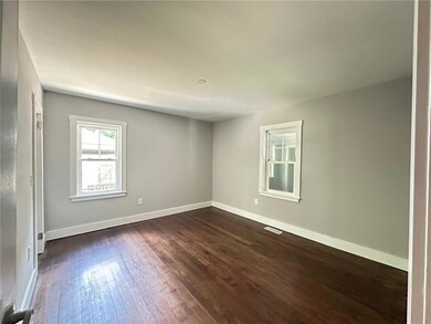 Empty room featuring dark wood finished floors and baseboards
