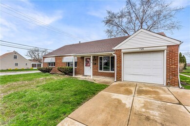 View of front of house with driveway, a front yard, brick siding, a garage, and a shingled roof
