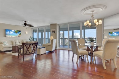 Open living area, warm wood flooring, direct access to screened lanai