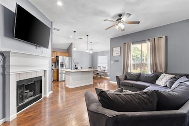 Living room featuring a ceiling fan, wood finishe