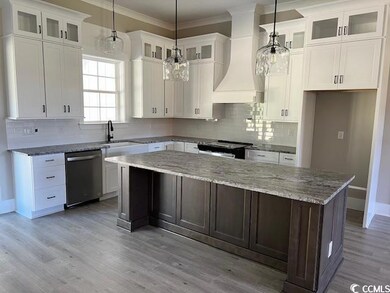 Kitchen featuring white cabinetry, stainless steel