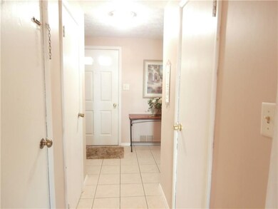 Neutral entryway with ceramic tile, coat closet an