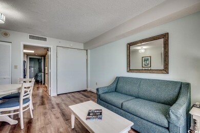 Living area featuring visible vents, a textured ce