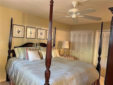 Bedroom with carpet floors, a ceiling fan, and two closets