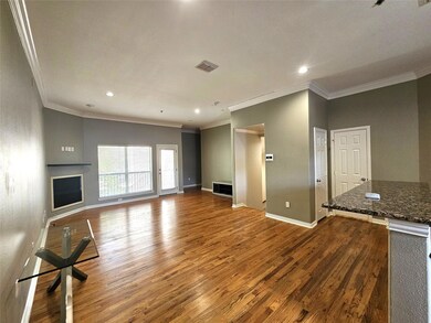Unfurnished living room featuring ornamental molding and wood-type flooring