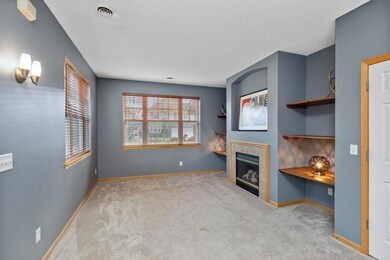 Big picture windows and newer carpet create a warm and appealing living room.