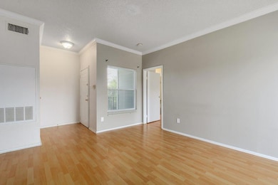 Empty room with ornamental molding, baseboards, a