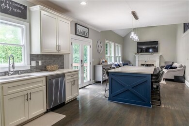 Kitchen with dishwasher, open floor plan, light countertops, dark wood finished floors, and lofted ceiling