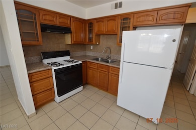 Kitchen with freestanding refrigerator, gas range,