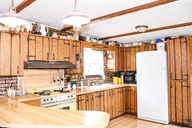 Kitchen featuring a sink, white appliances, light 