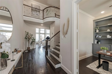 Foyer with ornamental molding and hardwood / wood-style floors