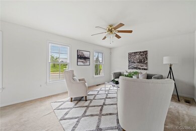 Living room featuring light colored carpet and ceiling fan