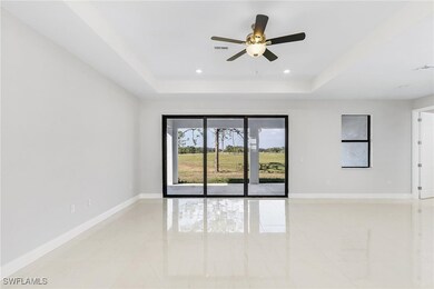 Spare room featuring a raised ceiling, ceiling fan