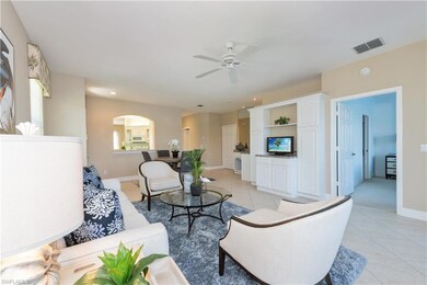 Living room featuring ceiling fan and light tile f