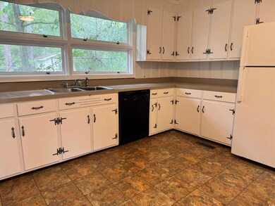 Kitchen with white refrigerator, sink, white cabin
