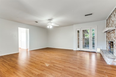 Unfurnished living room with light wood-style floors, a ceiling fan, and a fireplace