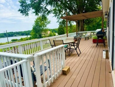 Wooden deck featuring a water view, outdoor dining area, and grilling area
